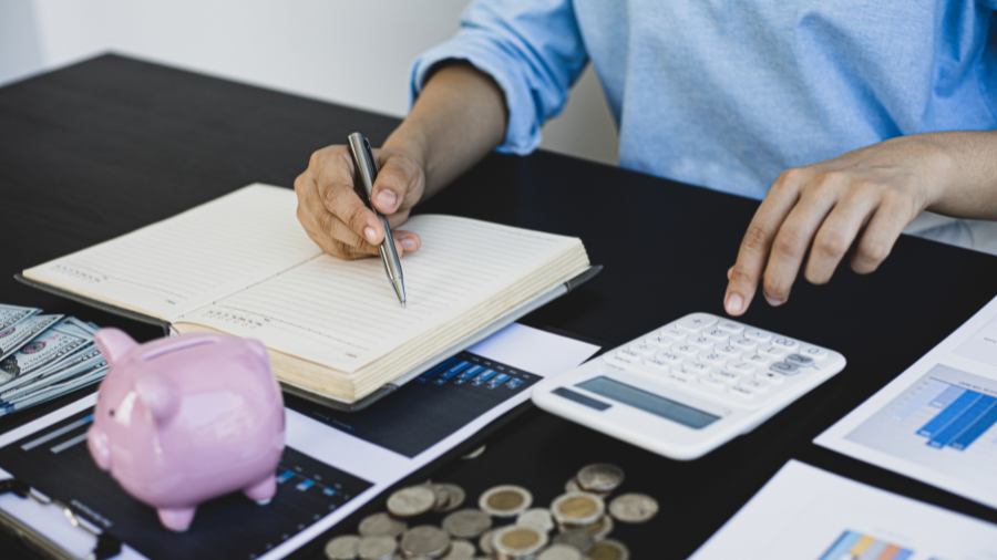 A woman using a tablet while holding a credit card, with two other cards on the desk.